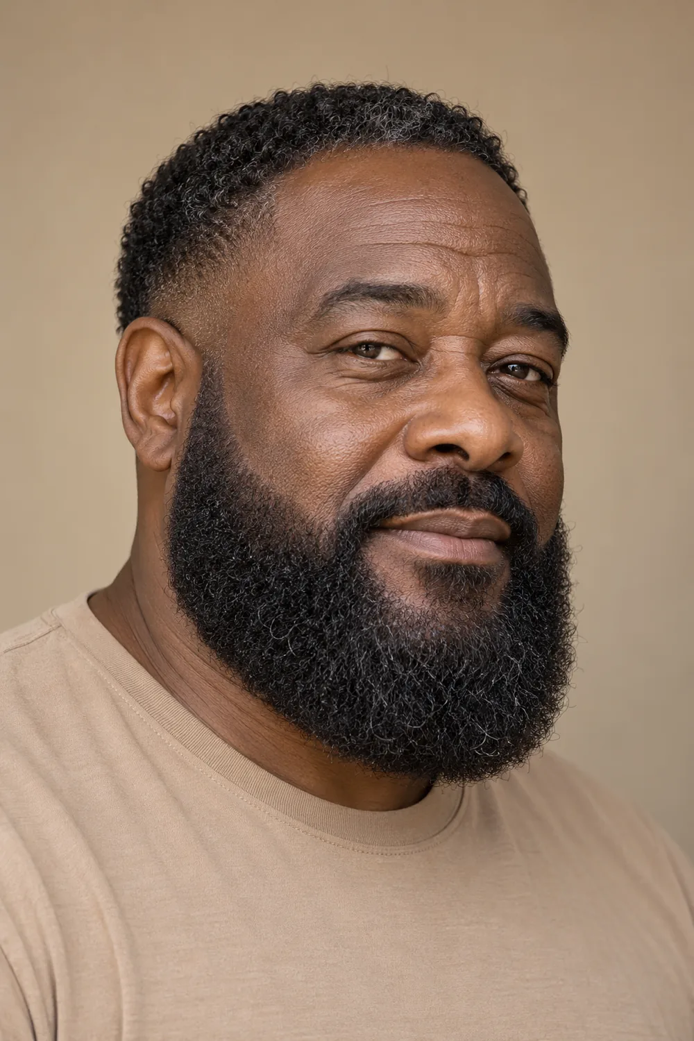 Fictional mature Black man in a tan crew-neck shirt, shown in three-quarter view with a broad, rounded dark beard, low soft cheek line, and connected mustache.