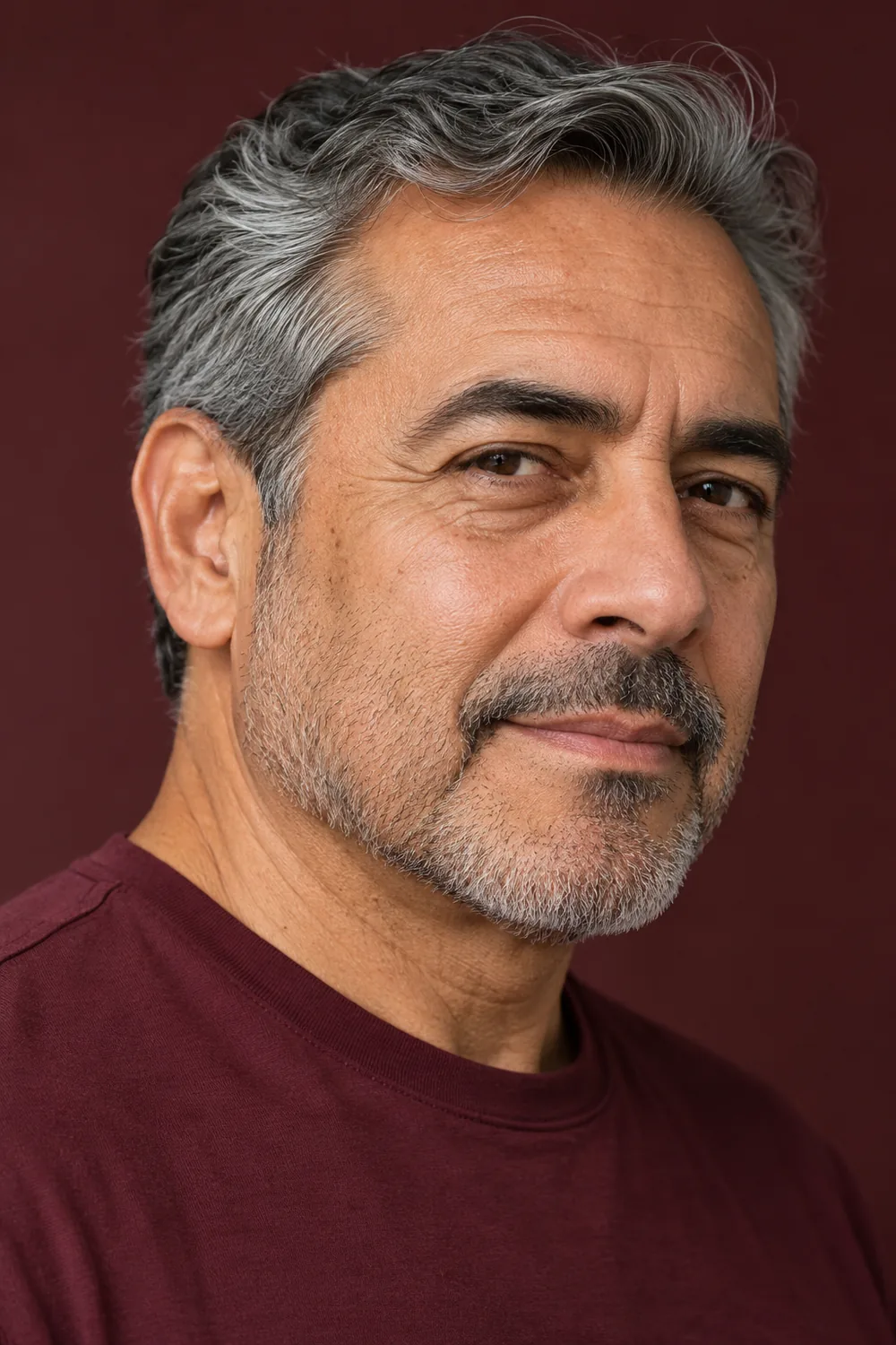 Mature man with close salt-and-pepper stubble, low cheek boundary and connected short mustache.