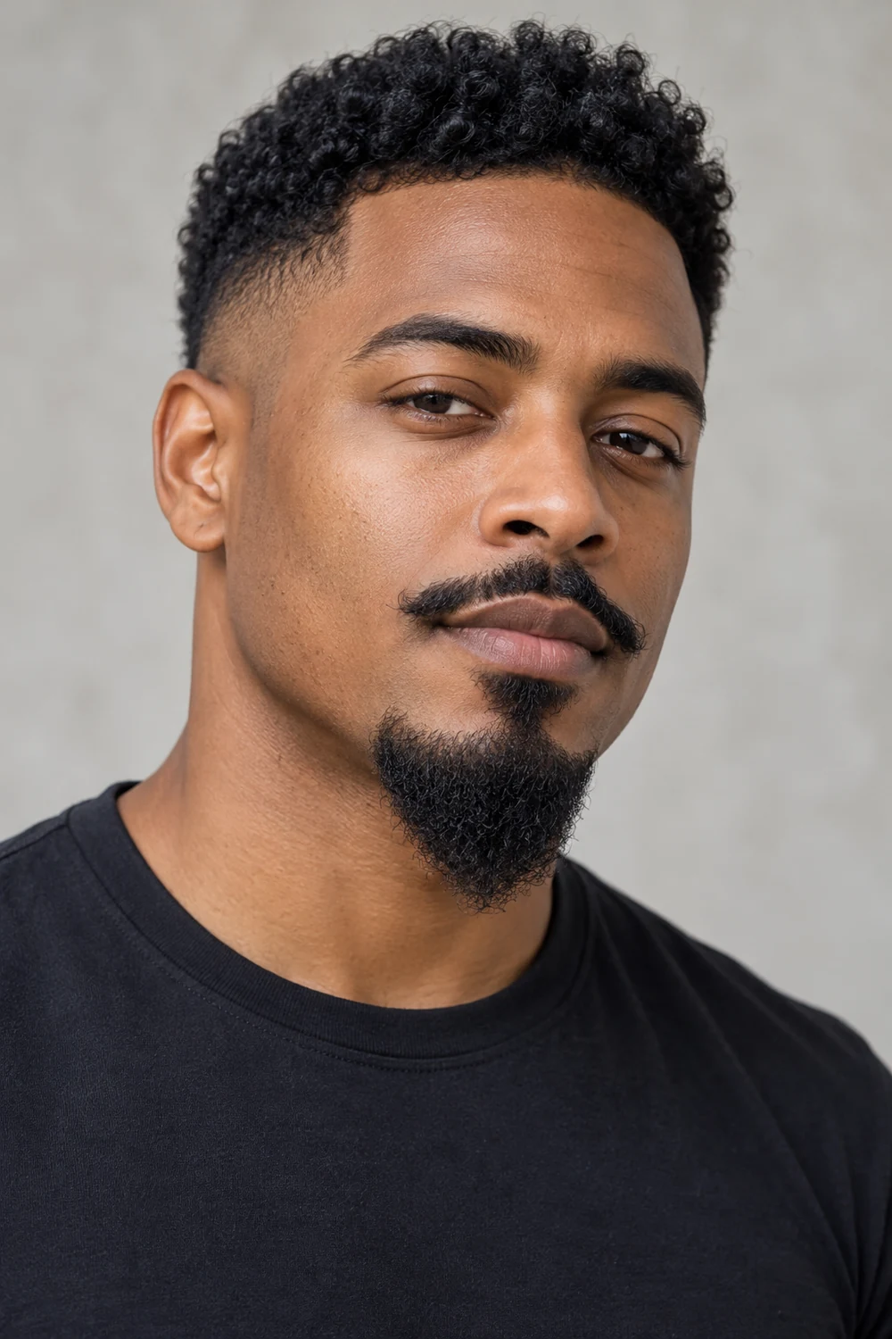 Adult Black man in a three-quarter portrait with a narrow pointed Van Dyke goatee, a separate curved mustache and clean-shaven cheeks.