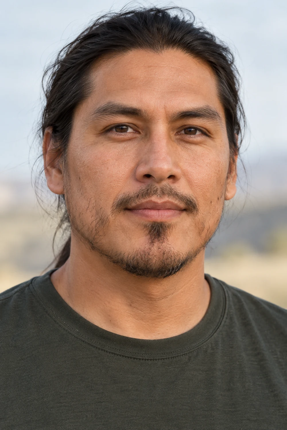Adult man with sparse cheek growth, a small rounded chin patch, and a light disconnected mustache.