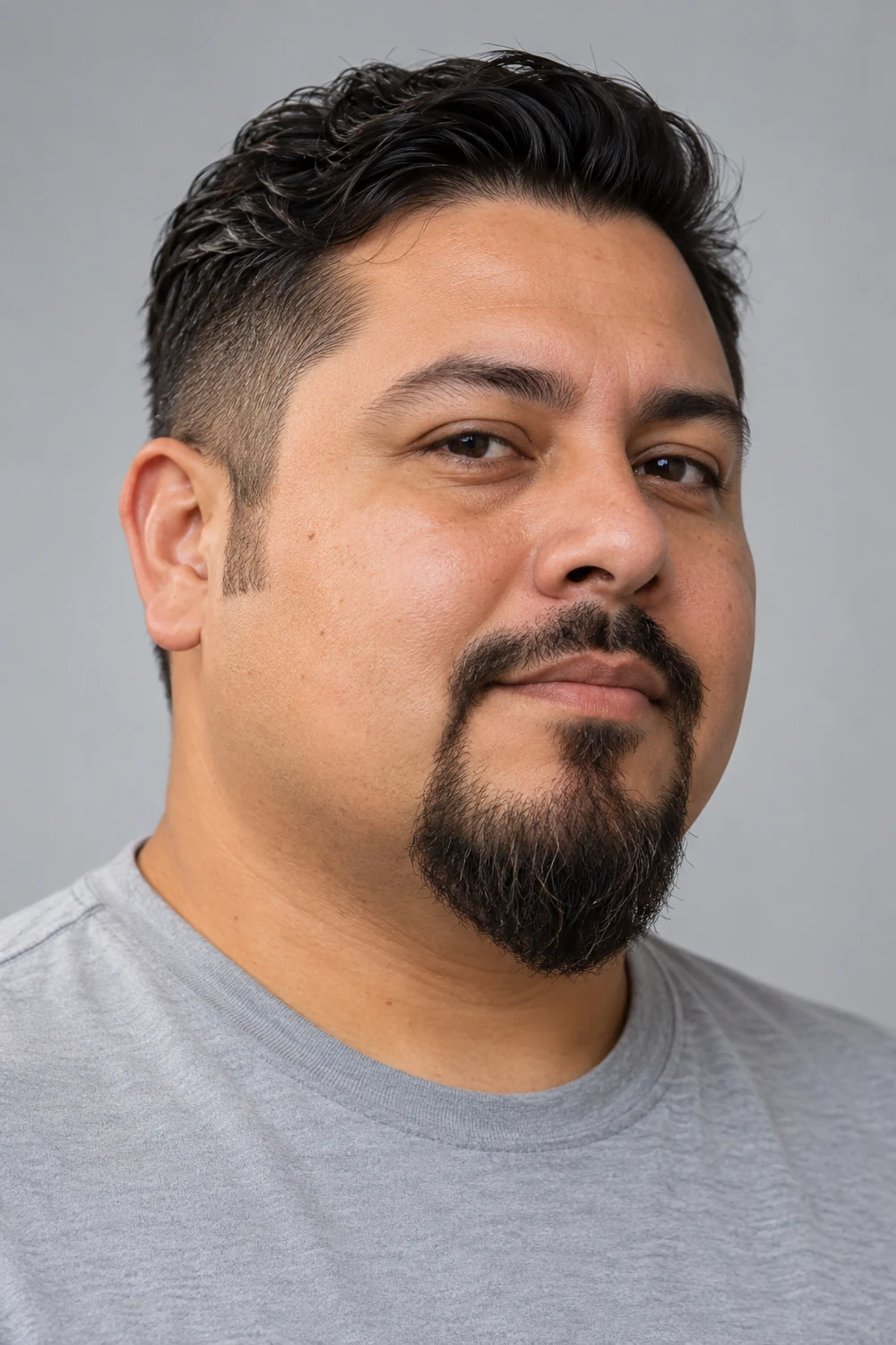 Fictional adult man with a round face wearing an extended goatee, connected narrow mustache, and clean-shaven cheeks.