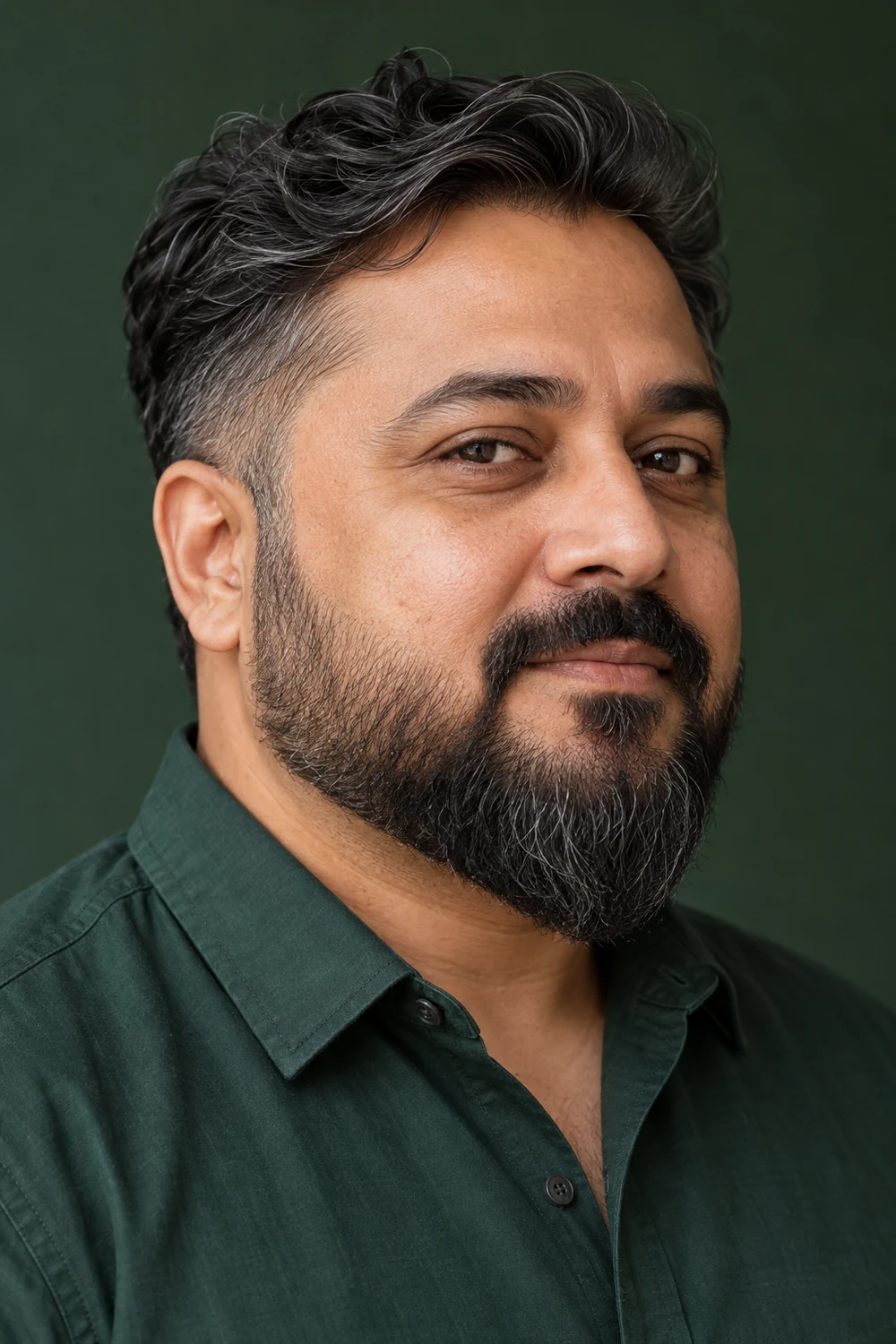 Fictional adult South Asian man with a round face wearing a medium beard with shorter sides, a fuller pointed chin, and a connected mustache.