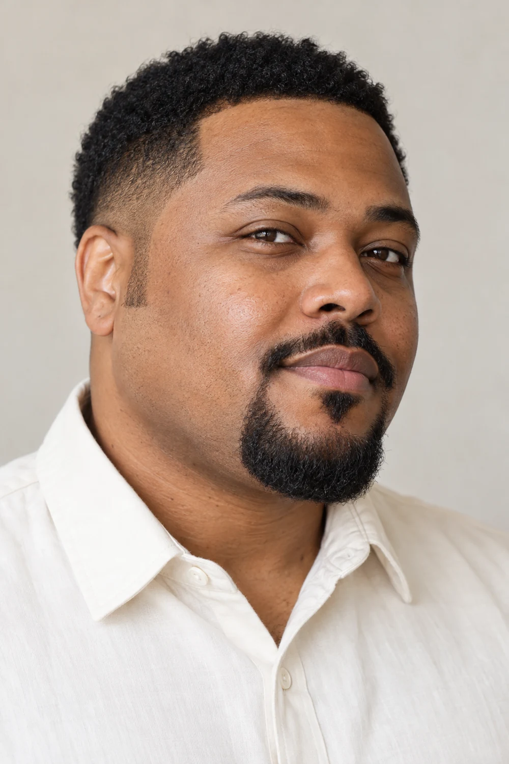 Three-quarter portrait of a fictional adult Black man with a round face, wearing a short rounded balbo beard, trimmed soul patch, separate mustache, and clean-shaven jaw sides.