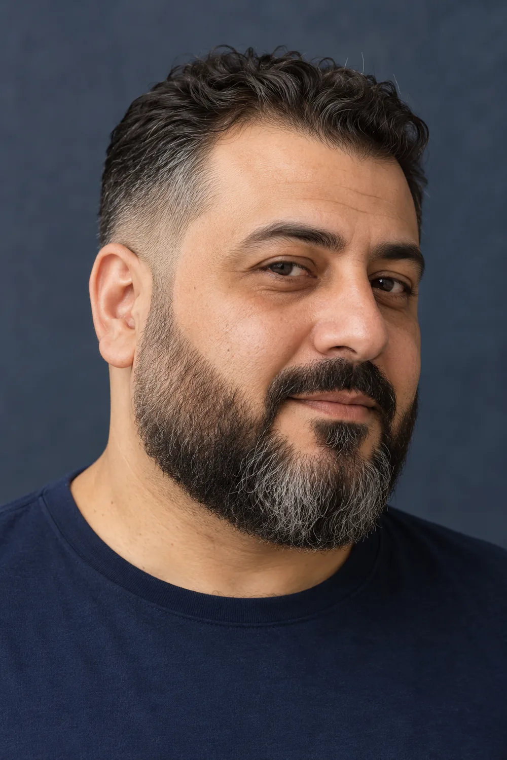 Fictional middle-aged man with a round face, shown in three-quarter view with a medium salt-and-pepper beard, faded sideburns, clean cheek lines, and a connected mustache.