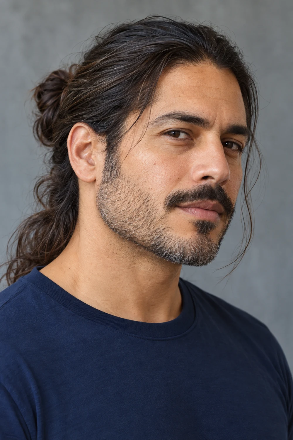 Fictional adult man with long dark hair tied back, short salt-and-pepper stubble, and a detached mustache, shown in three-quarter view.