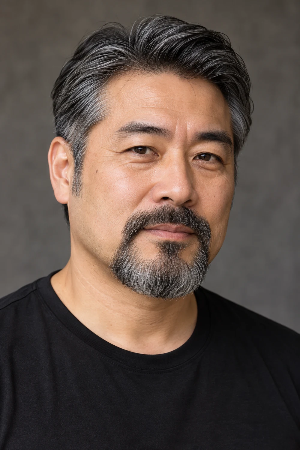 Fictional adult East Asian man in a black shirt wearing a dense salt-and-pepper circle beard with a connected mustache, broad softly squared chin, and shaved cheeks.