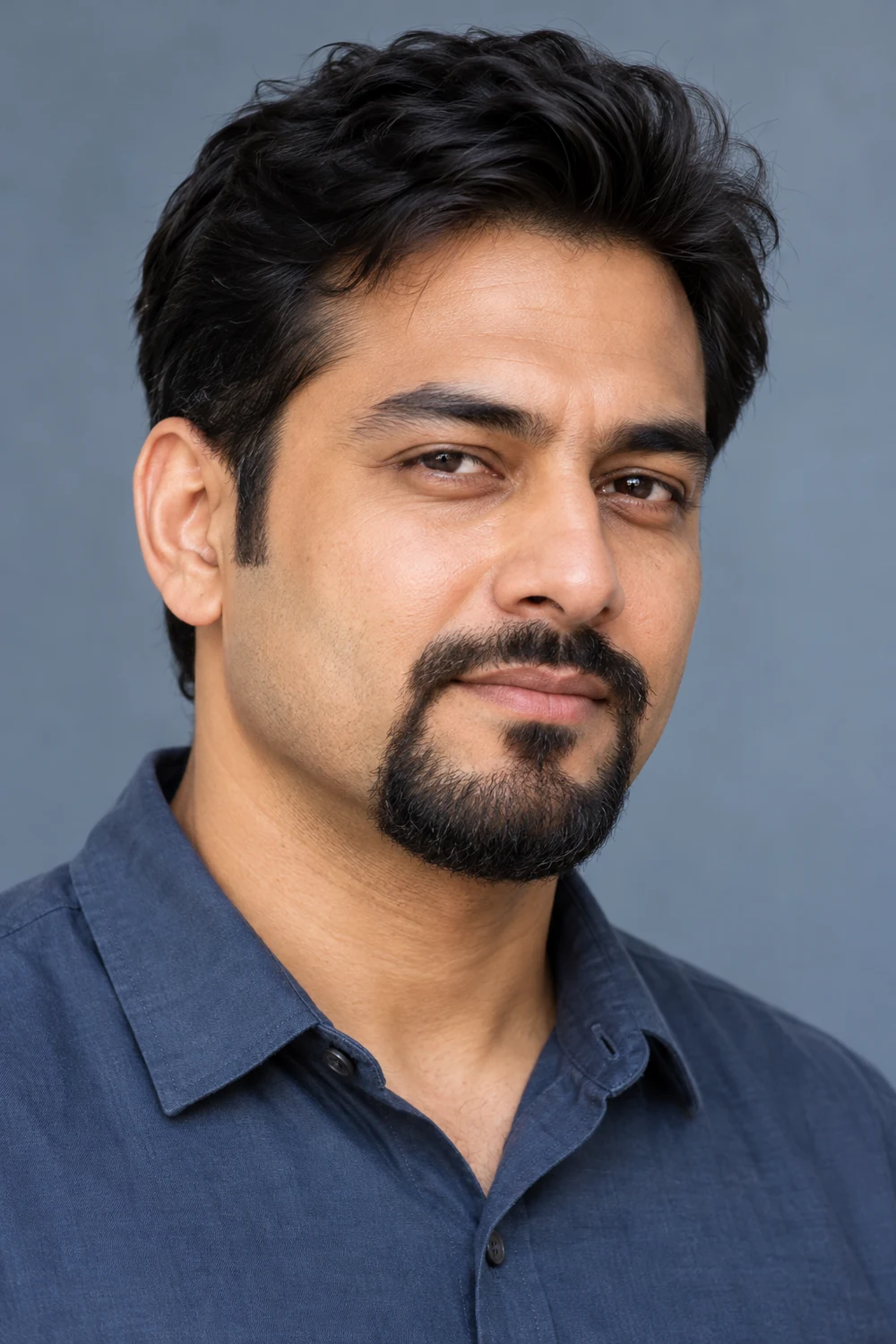 South Asian adult man with a narrow mustache connected at both corners to a fuller chin beard, with shaved cheeks.