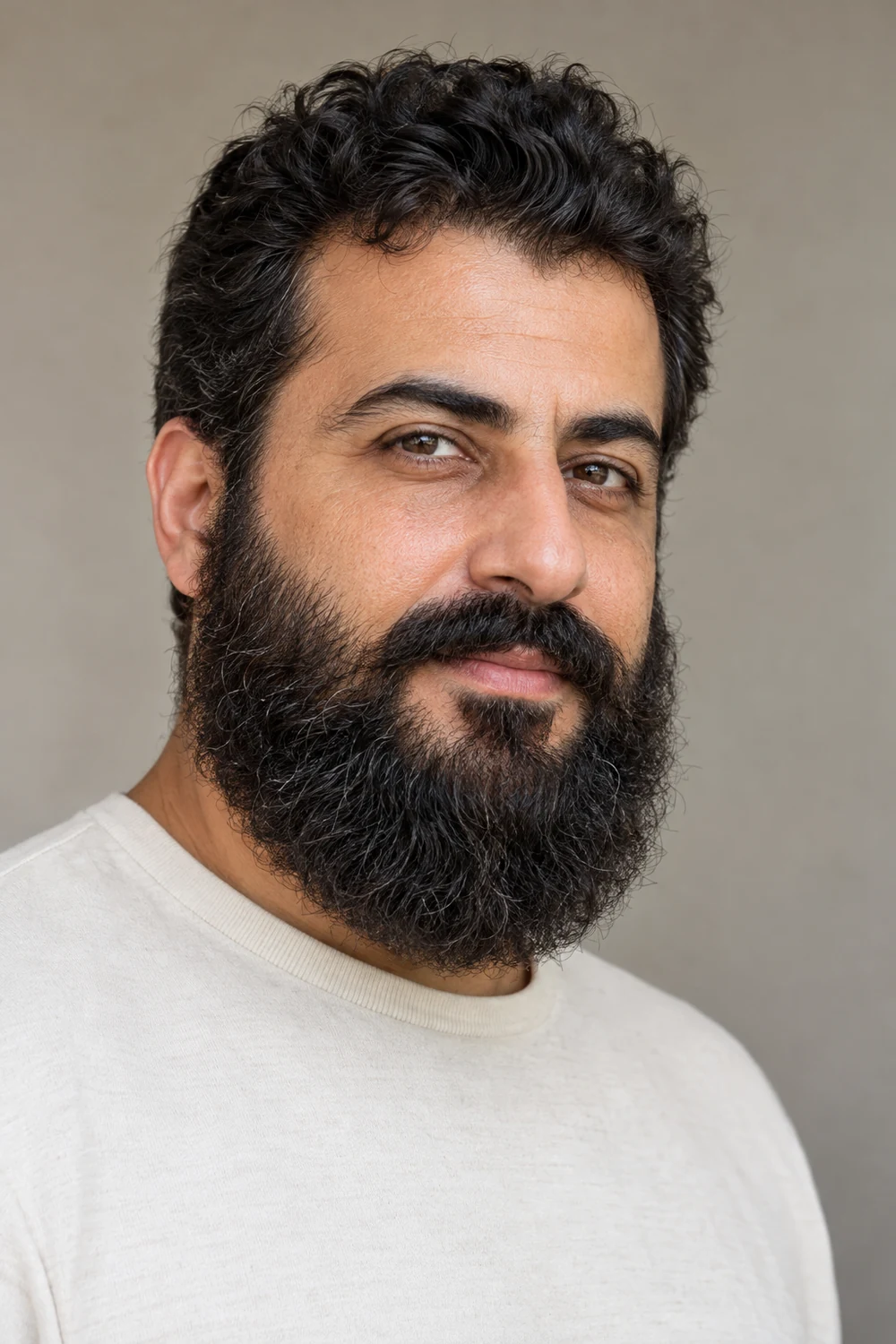 Adult man with softly edged cheek lines, textured full sides, and a rounded Garibaldi beard with a connected mustache.