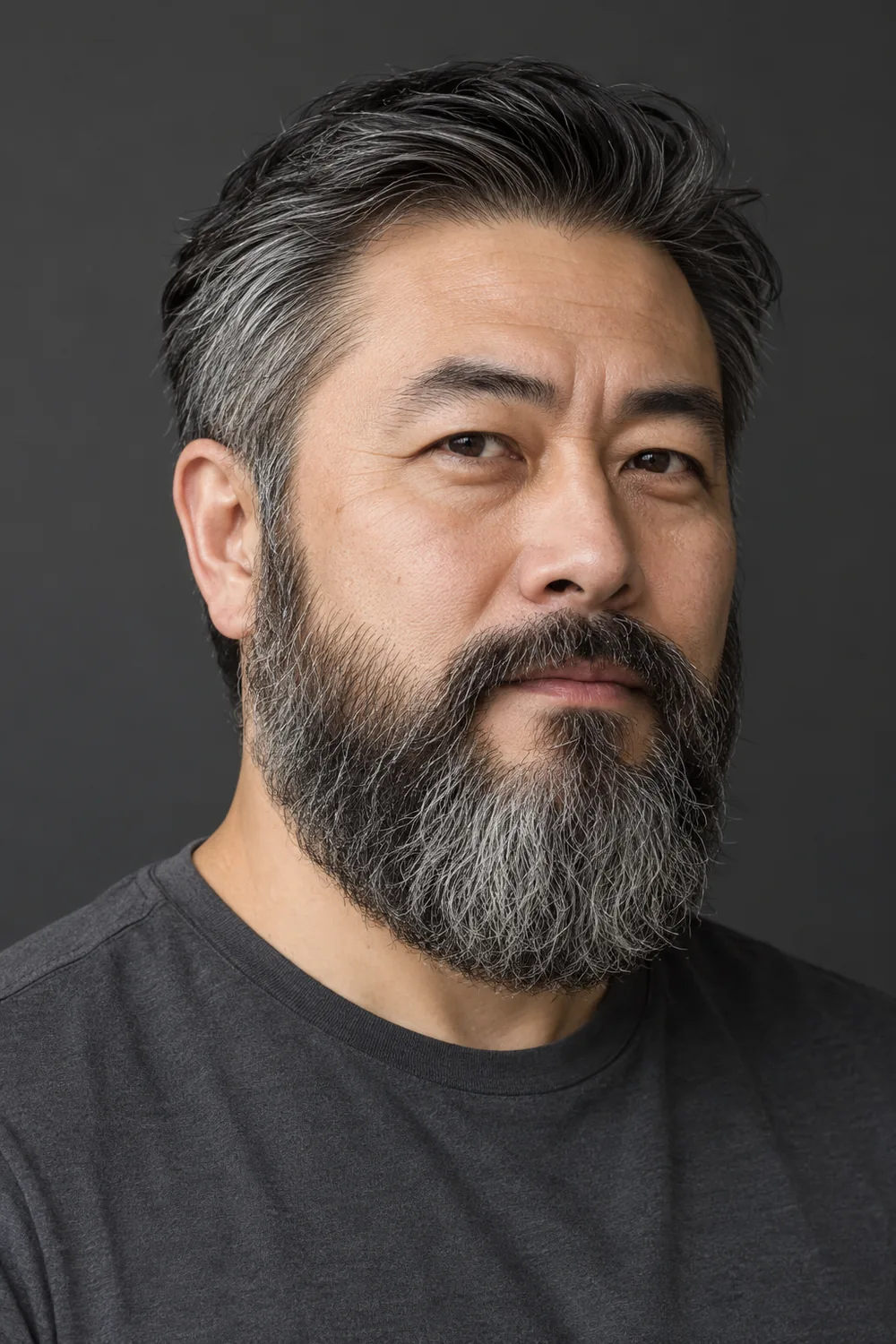 Fictional East Asian man in a dark gray shirt, shown in three-quarter view with a broad salt-and-pepper Garibaldi beard, full cheeks, rounded base, and neatly trimmed connected mustache.