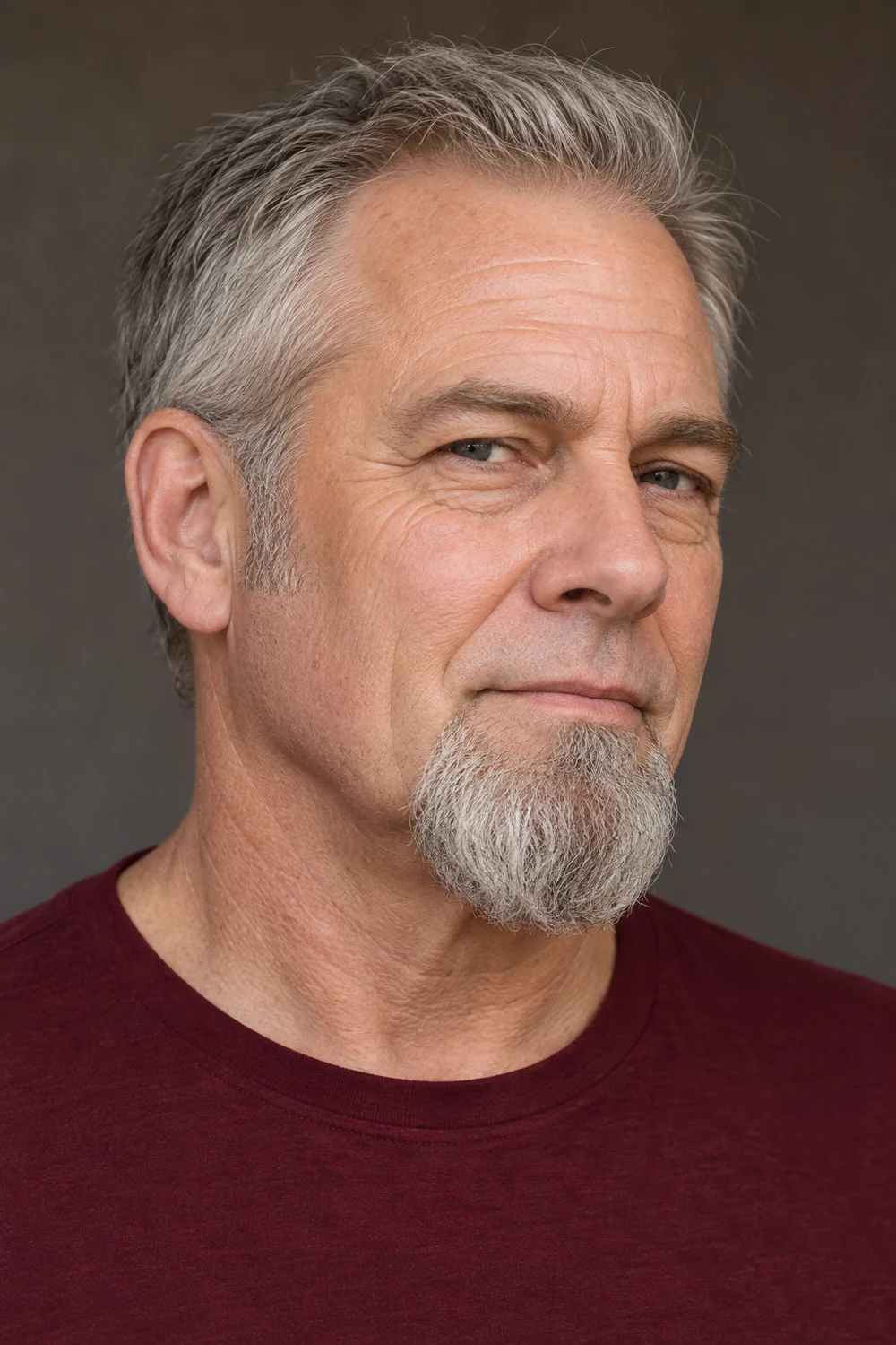 Three-quarter portrait of an older man with a rounded gray chin goatee, bare skin beneath the lower lip, and a clean-shaven upper lip.