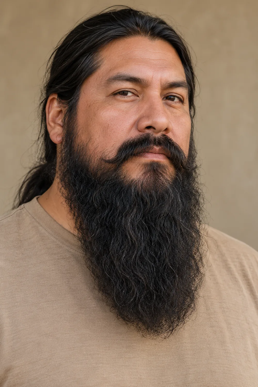 Three-quarter portrait of an adult man with a long, coarse wavy black beard, low cheek boundary, rounded visible tip, and connected mustache.