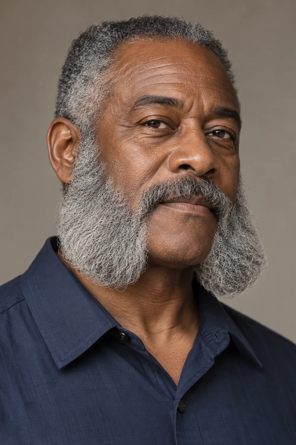 A mature Black man with long, rounded gray mutton chops, a separate mustache, and a clean-shaven chin.