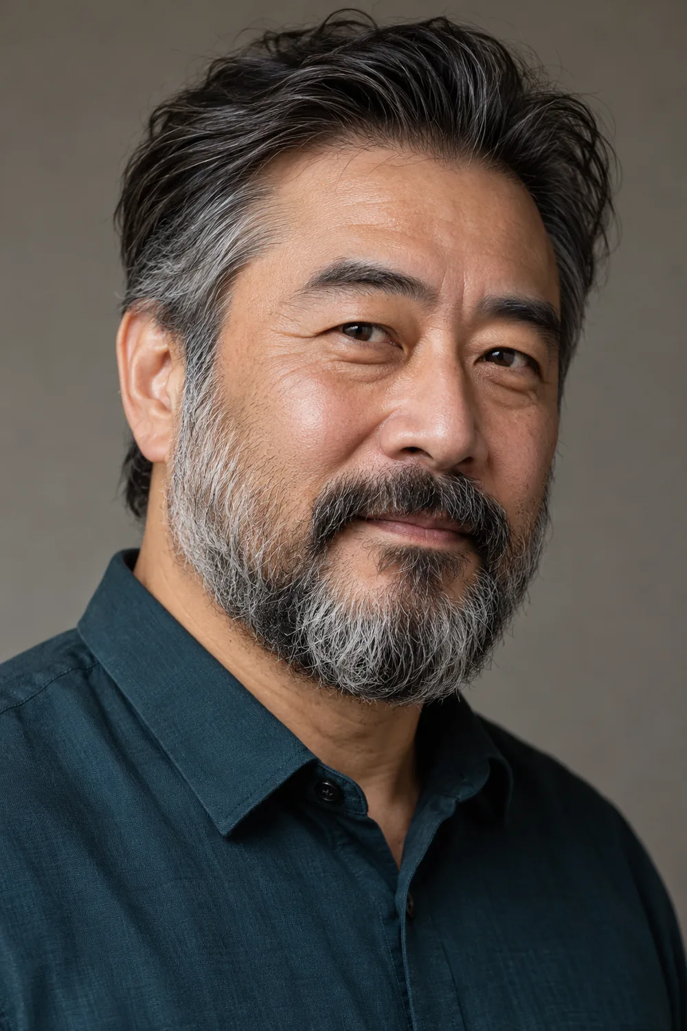 Three-quarter portrait of an adult East Asian man with a short, dense salt and pepper beard, broad connected mustache, and naturally soft cheek edges.