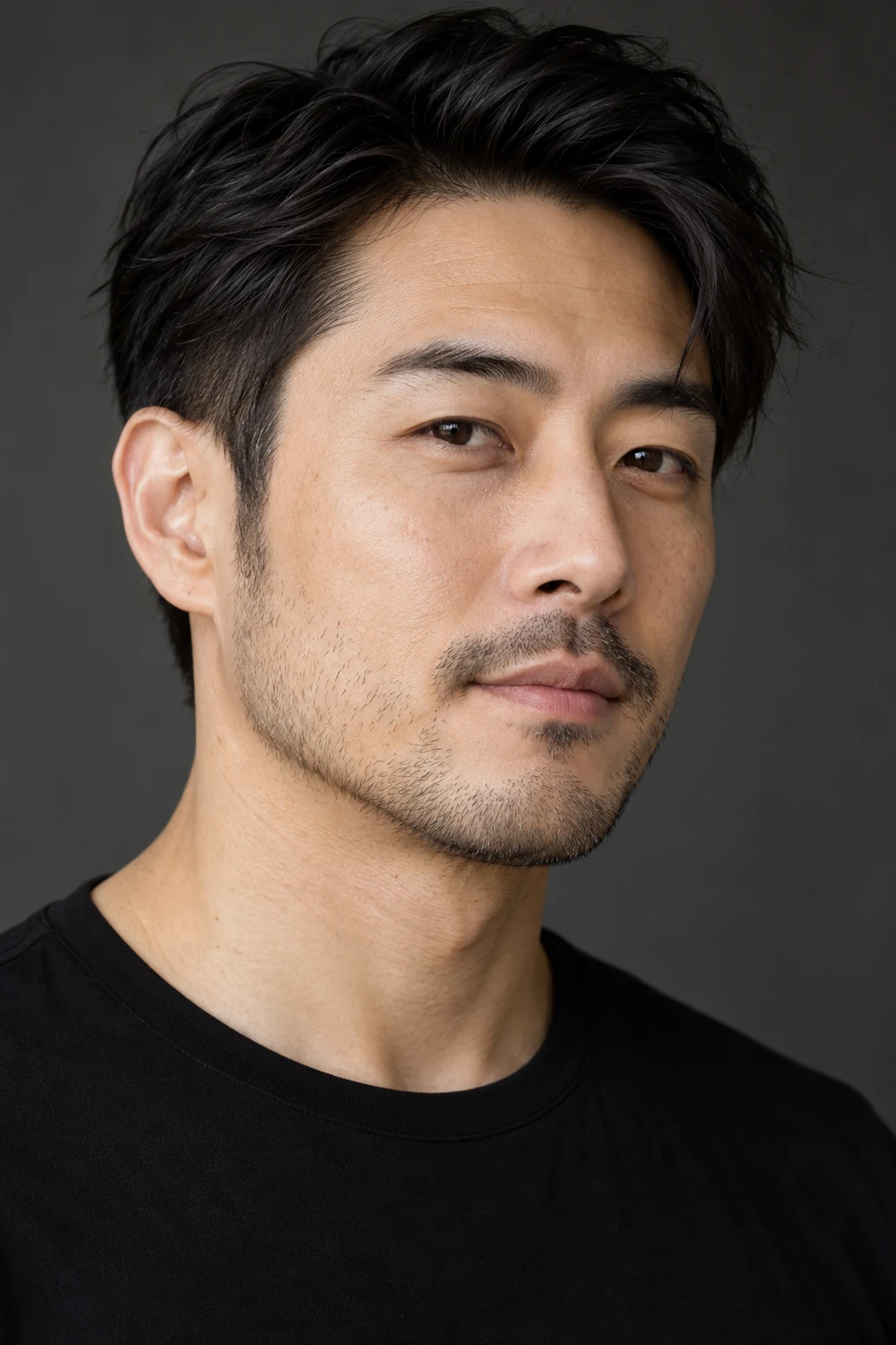 Fictional adult East Asian man in a black crew-neck shirt, with fine short stubble tapering toward a pointed chin and a slim connected mustache.
