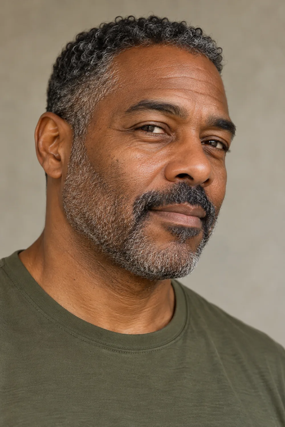 Three-quarter portrait of a fictional adult Black man with salt-and-pepper short stubble, lighter cheek coverage, and a fuller mustache connected at both corners.