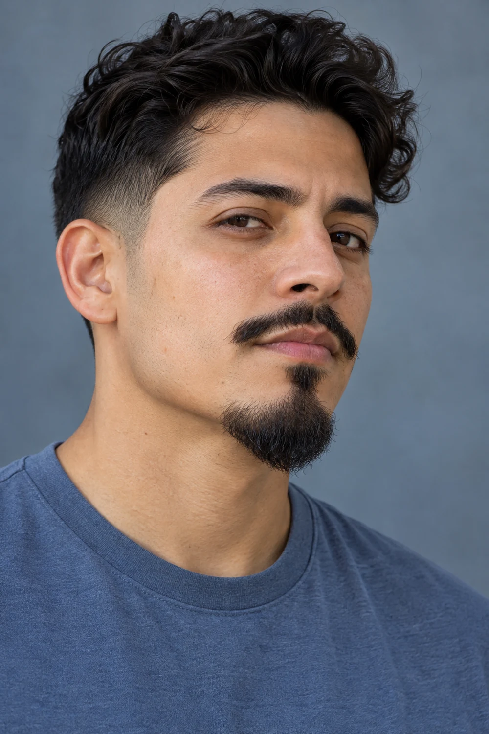 Three-quarter portrait of an adult man with short faded sideburns, clean-shaven cheeks, a separate narrow mustache, and a softly pointed Van Dyke chin beard.